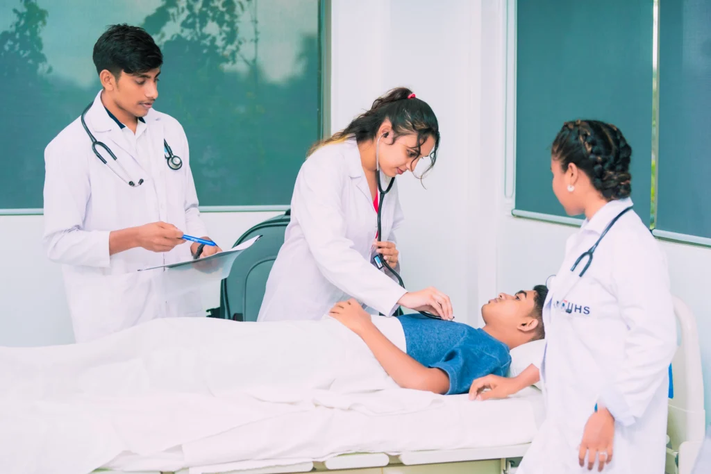 Three doctors in white coats attend to a patient in a hospital bed above ground level.]?